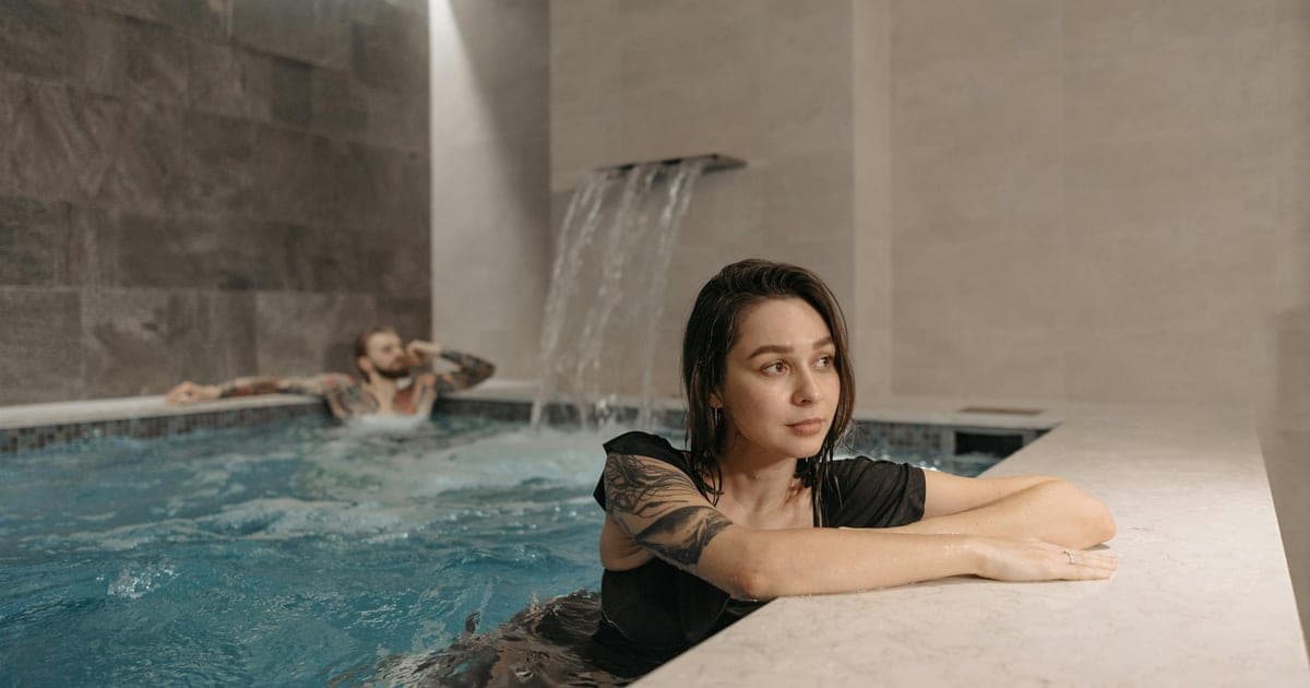 Person standing at the edge of a cold plunge pool deciding when to take the plunge, illustrating the timing strategy for cold immersion and muscle growth