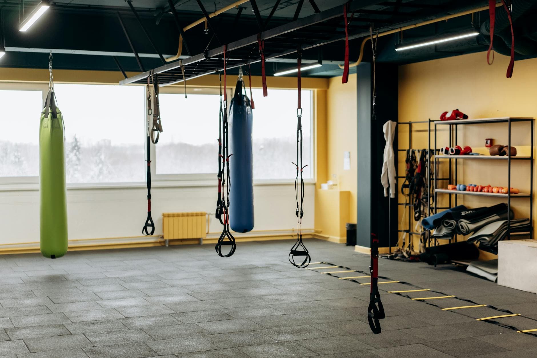 Modern Dubai gym interior with floor-to-ceiling windows showing the city skyline, weight rack in the foreground