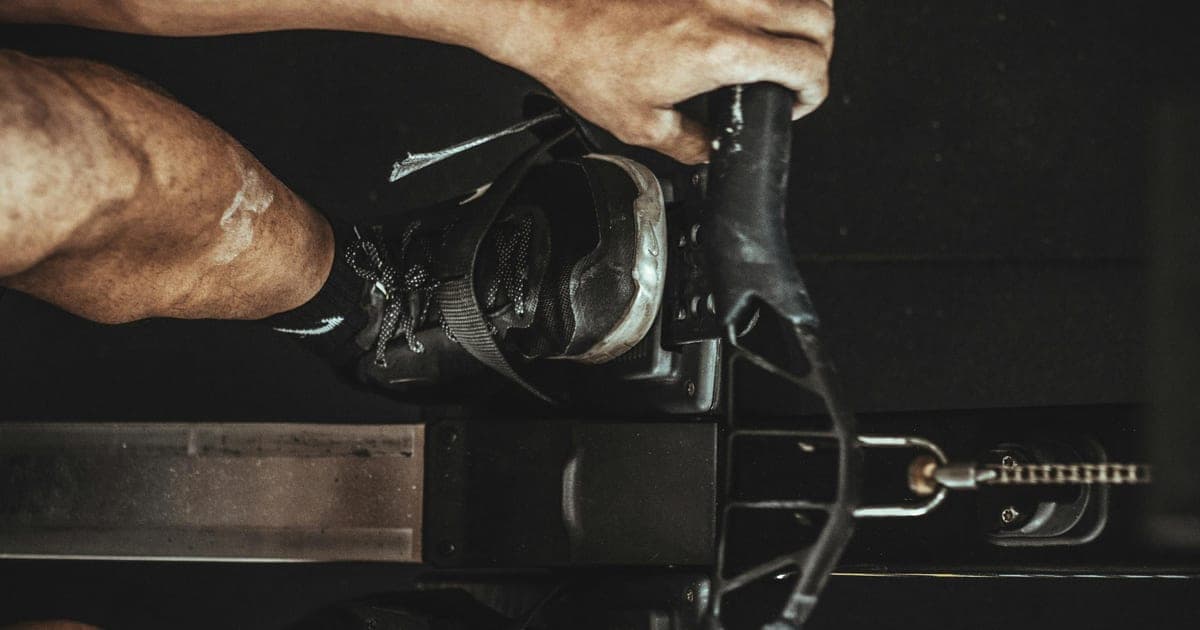 Person transitioning between paired exercises in a gym, illustrating agonist-antagonist superset training