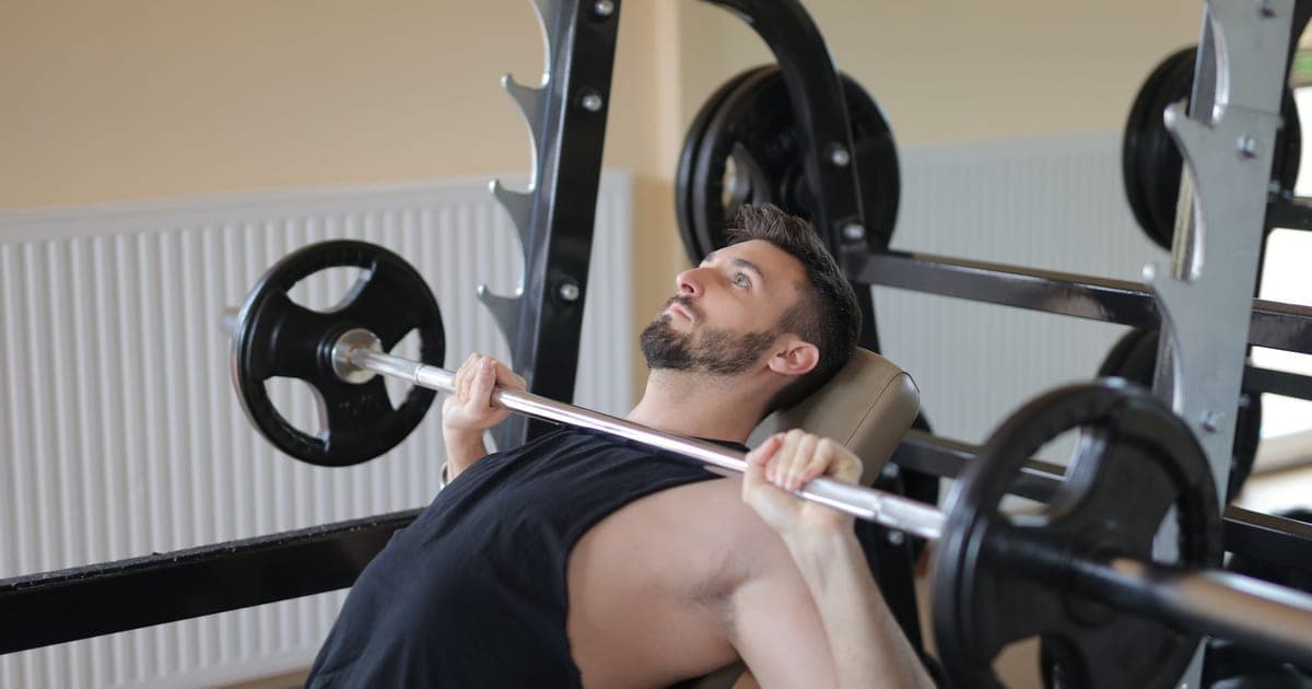 Lifter mid barbell bench press, the lift that earns fractional set credit for chest, triceps and front delts